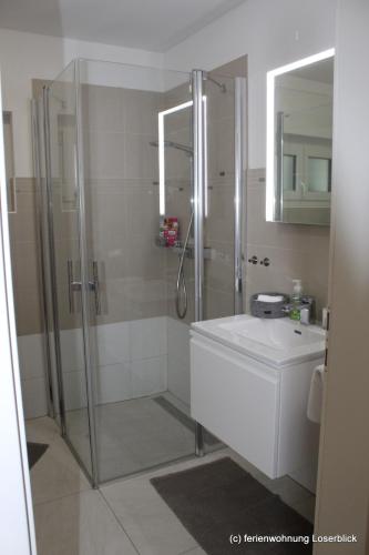 a bathroom with a shower and a toilet and a sink at Ferienwohnung Loserblick in Bad Aussee