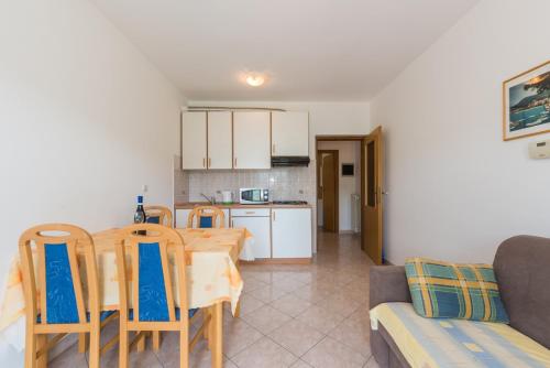 a kitchen and dining room with a table and chairs at Apartments Villa Adria in Rabac