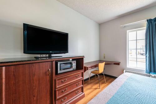 a bedroom with a flat screen tv on a dresser at Motel 6-Shreveport, LA in Shreveport
