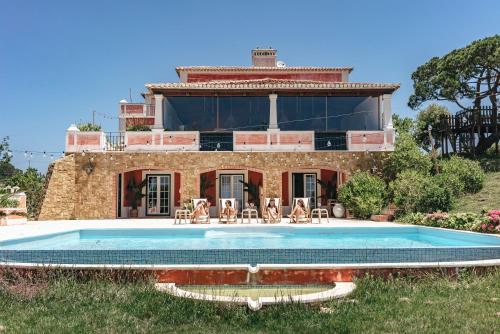 a house with a swimming pool in front of it at Dreamsea Surf Guest House in Sintra