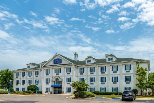 a large white building with a car parked in front of it at Motel 6-Shreveport, LA in Shreveport