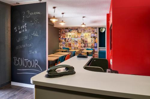 a restaurant with a counter with a chalkboard on the wall at hotelF1 Strasbourg Pont de l'Europe in Strasbourg