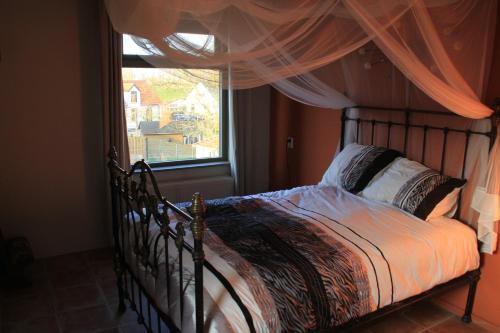 a bedroom with a bed and a window with curtains at Waard van Kekerdom in Kekerdom