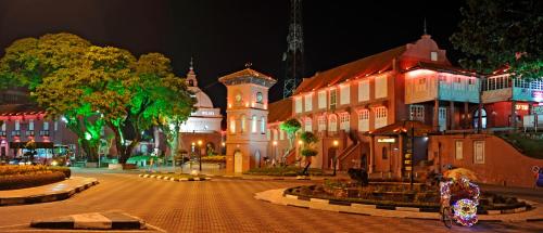 a city street at night with a group of buildings at Cozy Riverside Hotel in Melaka