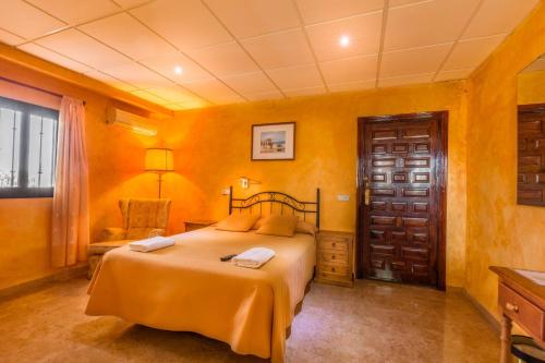 1 dormitorio con paredes amarillas y 1 cama en una habitación en Hotel Molino De Saydo, en Mollina