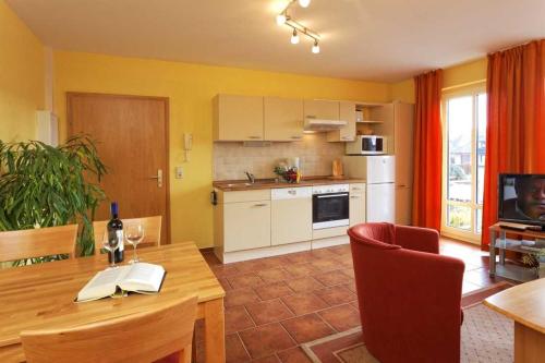 a kitchen with a wooden table and a dining room at Haus Clara Wohnung 06 in Ostseebad Koserow