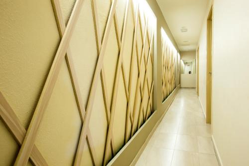 a corridor of a hospital hallway with wooden patterns on the walls at Hotel CIQ @ Wong Ah Fook in Johor Bahru