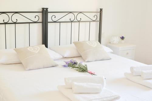 Una cama blanca con toallas blancas y flores. en Casa Chiara Verona, en Verona