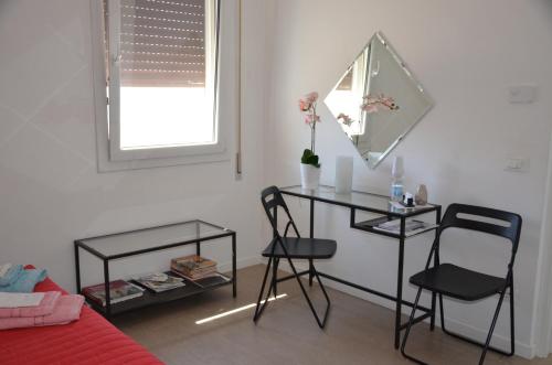um quarto com uma mesa e duas cadeiras e um espelho em B&B La Via dell'Ambra em Due Carrare