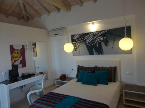 - une chambre avec un lit doté d'oreillers bleus et de deux lumières dans l'établissement Skiathos Garden Cottages, à Skiathos Chora