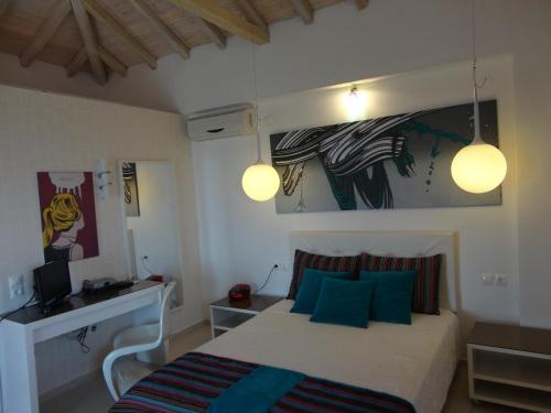 1 dormitorio con 1 cama con almohadas azules y 2 luces en Skiathos Garden Cottages en Skiathos