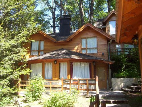 a wooden house with a fence in front of it at Cabañas Temporada in San Martín de los Andes