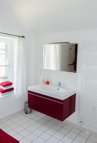 a white bathroom with a sink and a mirror at La Moutière in Colonzelle