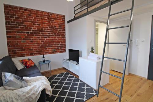 a living room with a loft bed and a brick wall at Aparthotel Tectum TectumApartments in Wrocław