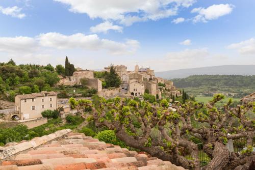 een oud dorp op een heuvel met bomen bij Mas des Romarins, The Originals Relais in Gordes