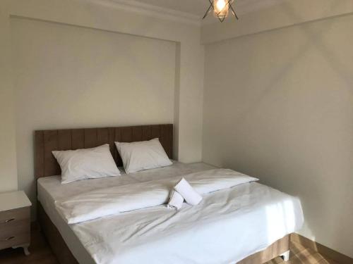 1 dormitorio con 1 cama con sábanas y almohadas blancas en Golden Arrow 3, en Estambul