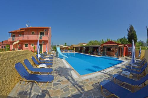 - une piscine avec des chaises longues et un toboggan dans l'établissement Othonas Apartments, à Sidari