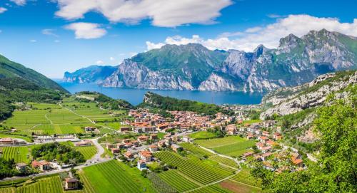 un pueblo a orillas de un lago frente a las montañas en Hotel Continental - TonelliHotels, en Nago-Torbole