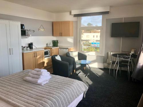 a bedroom with a bed with towels on it at The Blenheim in Dawlish