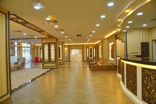 a hallway with a lobby with wooden floors and doors at Muscat Plaza Hotel in Muscat