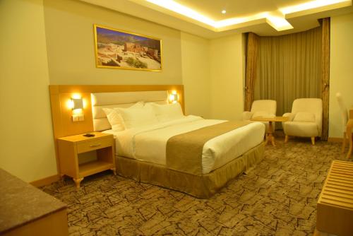 a hotel room with a bed and a table and chairs at Muscat Plaza Hotel in Muscat