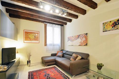 a living room with a couch and a tv at Cà Mocenigo Suite in Venice