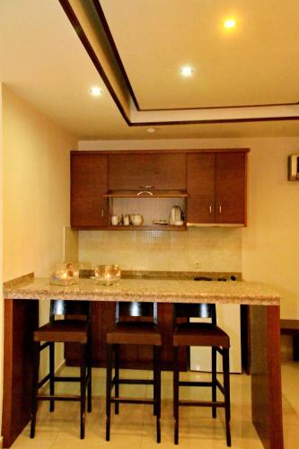 a kitchen with a counter and some stools at 24 Seven Boutique Hotel in Malia