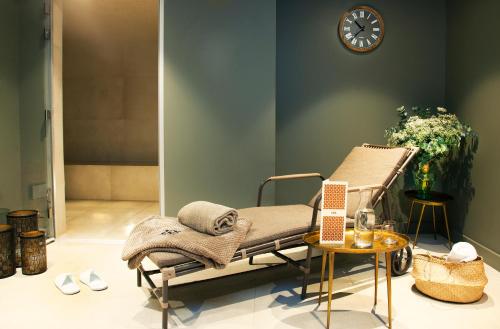 a hospital bed in a room with a clock on the wall at Relais de Chambord, a Small Luxury Hotels of the World in Chambord