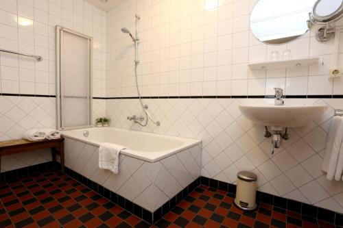 un baño con bañera y lavabo en Graanzicht, en Midwolda