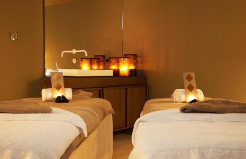 a bathroom with two beds and a sink with lights at Relais de Chambord, a Small Luxury Hotels of the World in Chambord