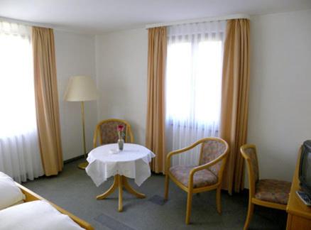 a hotel room with a table and chairs and a bed at Hotel Restaurant Adler Bühlertal in Bühlertal