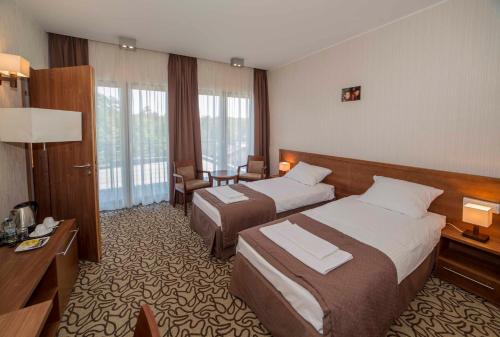 Pokój hotelowy z 2 łóżkami i biurkiem w obiekcie Centrum Wypoczynkowo-Konferencyjne Solaris w Łazach