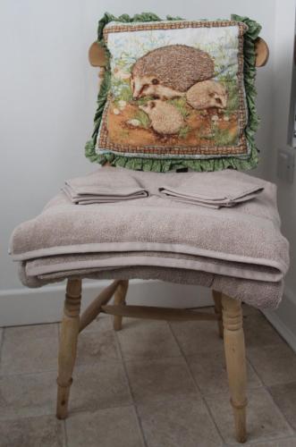 a blanket sitting on top of a wooden chair at Forest Farm Papplewick Nottingham - Spacious Self-Contained Rural Retreat! in Papplewick