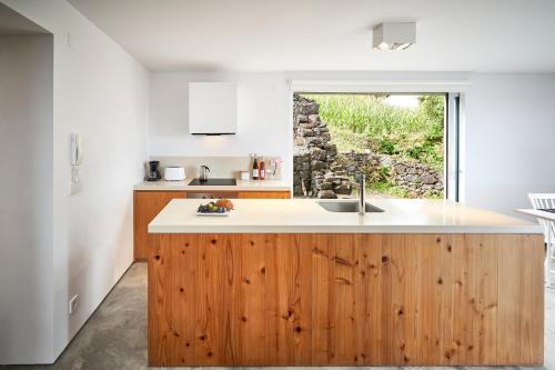 a kitchen with a wooden counter and a window at Casa do Ferreiro in São Miguel Arcanjo
