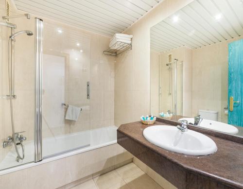 a bathroom with a sink and a shower and a tub at Globales Los Patos Park in Benalmádena