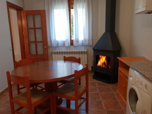 a dining room with a table and a fireplace at Apartaments Cal Noi in Camprodon