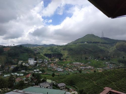 a view of a town with mountains in the background at Misty Mountain Villas in Nuwara Eliya