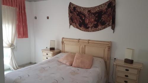 ベニドルムにあるEl Barcoのベッドルーム1室(ピンクの枕が付いたベッド1台付)