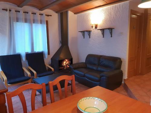 a living room with a table and a couch and a fireplace at Apartaments Can Bundanci in Setcases