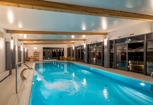 a large swimming pool in a building with a swimming pool at Centrum Wypoczynkowo-Konferencyjne Solaris in Łazy