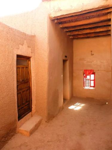 an empty room with a door and a window at kasbah timidarte in Zaouïta Bou Lhâssane