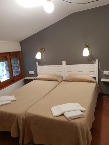 two beds in a bedroom with two white towels on them at Apartaments Can Bundanci in Setcases