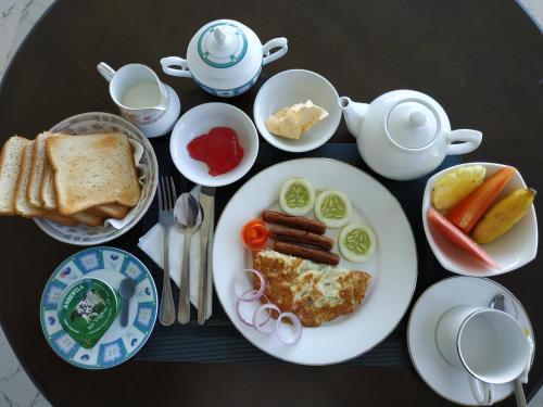 a table topped with a plate of food with breakfast foods at Villa Lemon Court in Nuwara Eliya