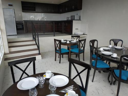 a dining room with tables and chairs and a kitchen at Villa Lemon Court in Nuwara Eliya