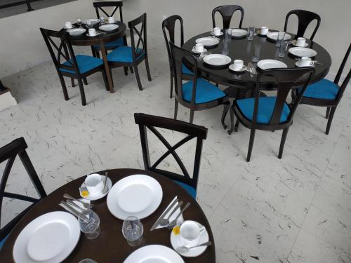 a dining room with black tables and blue chairs at Villa Lemon Court in Nuwara Eliya