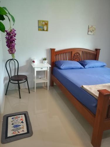 a bedroom with a bed and a chair and a table at Mae Pon Hostel in Khao Lak