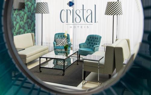 a mirror reflection of a hotel lobby with chairs and tables at Hotel Cristal Marinha in Marinha Grande