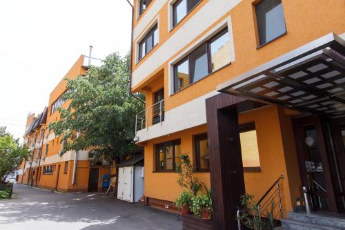 een oranje en wit gebouw naast een straat bij Hotel Anna in Târgu Jiu