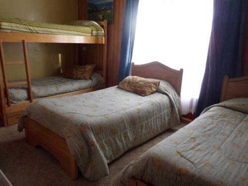 a bedroom with two bunk beds and a window at Hostel Danicar Puerto Natales in Puerto Natales