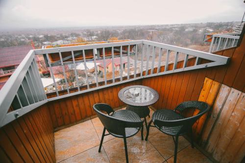 a balcony with four chairs and a table with a view at Savaneti Eco Hotel in Tʼelavi